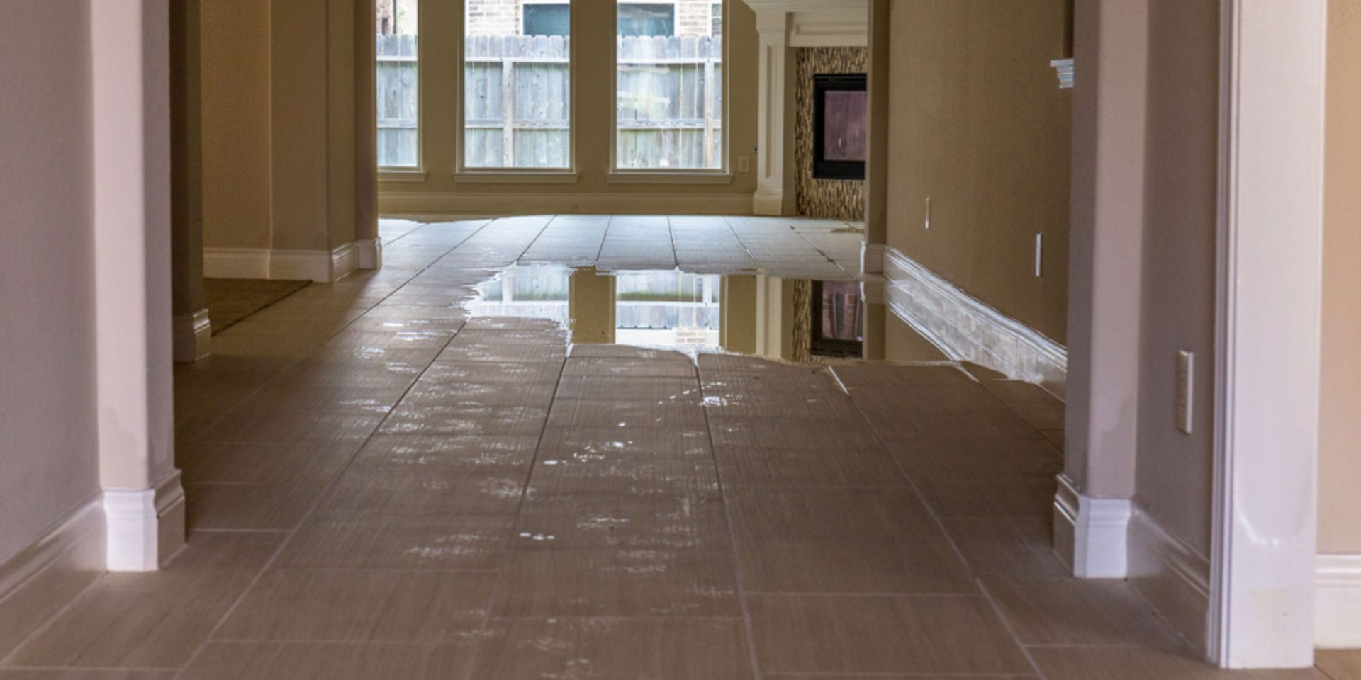 Expert cleaning water-damaged floors in a flooded home using advanced tools.