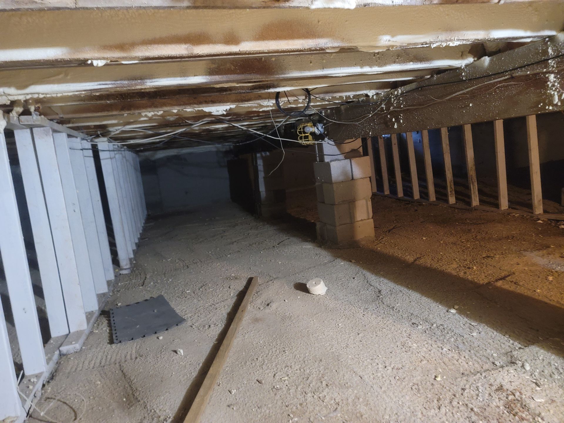 A very dark basement with a lot of wooden beams and boxes.
