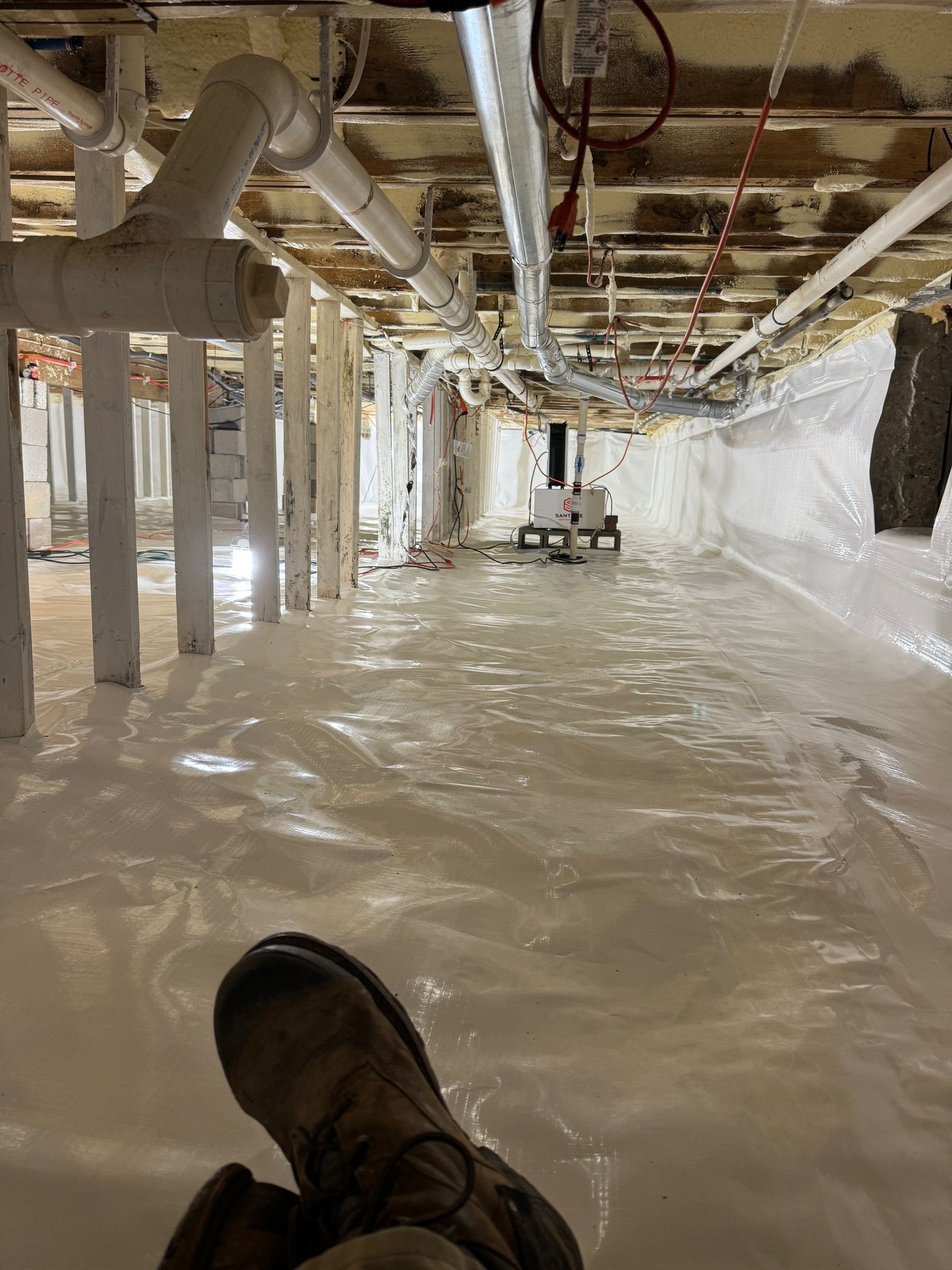 A person is laying on the floor of a flooded basement.