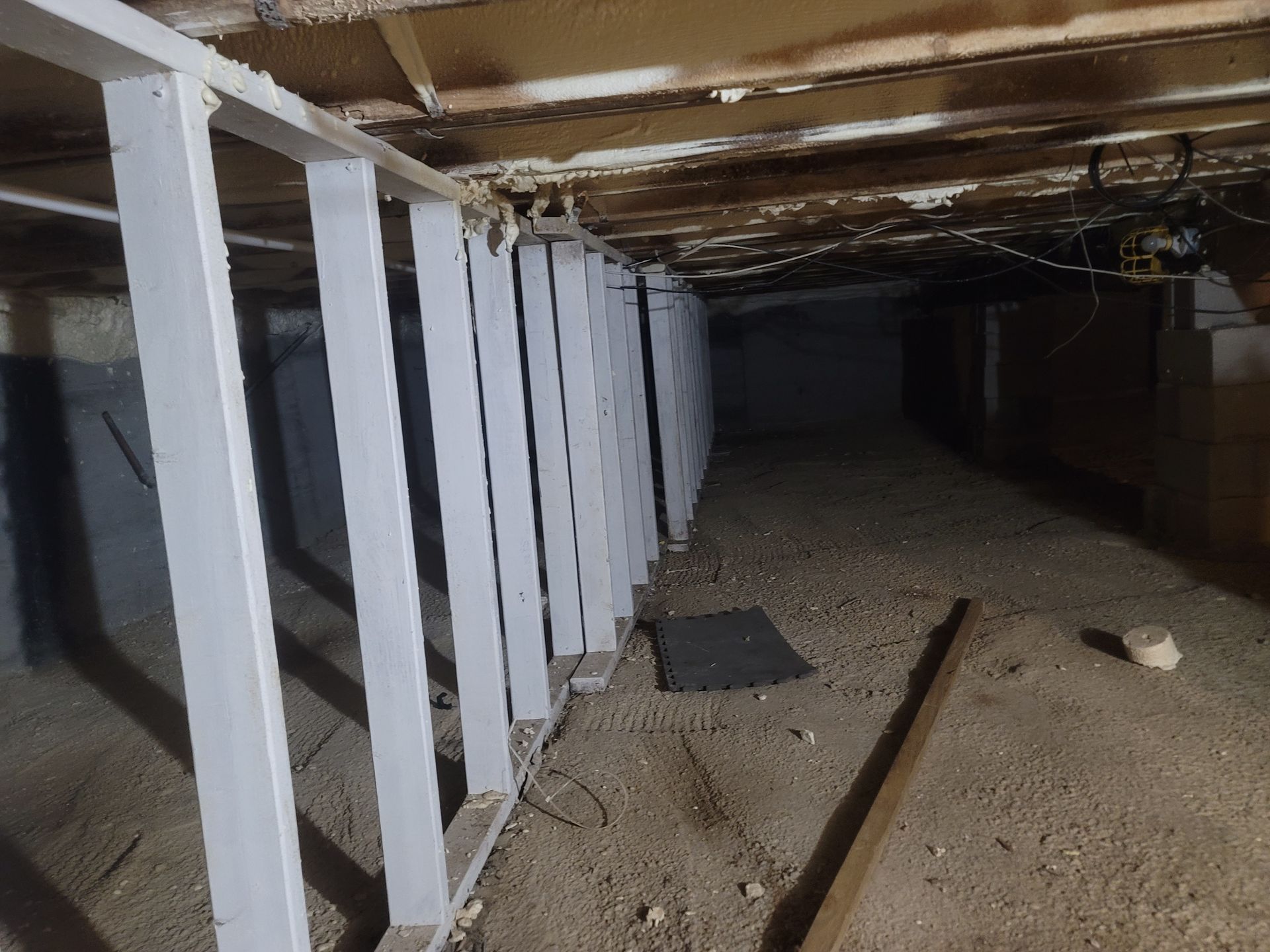 A very dark basement with a row of white pillars.