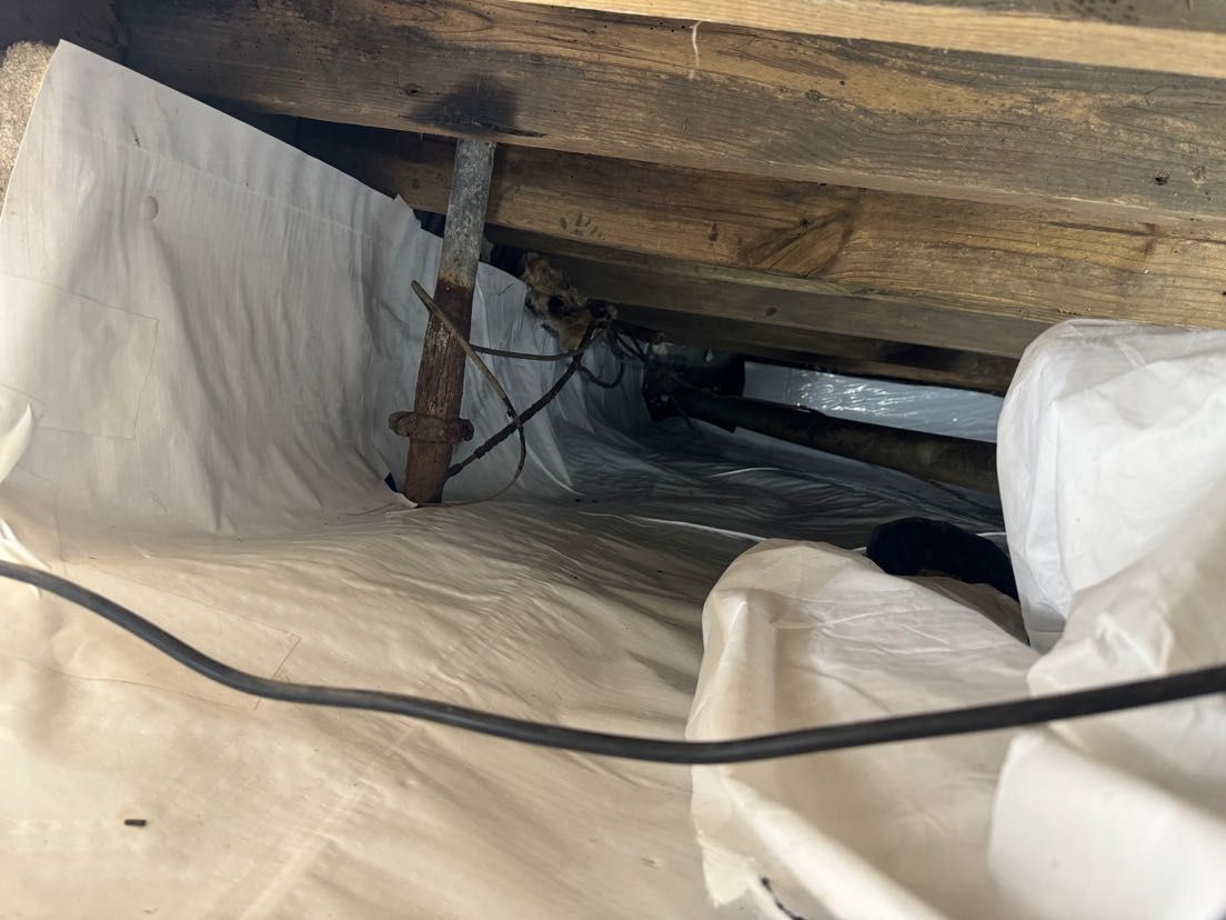 A bunch of electrical wires are laying under a wooden floor.