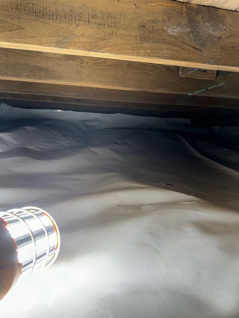 A person is holding a flashlight under a wooden ceiling.