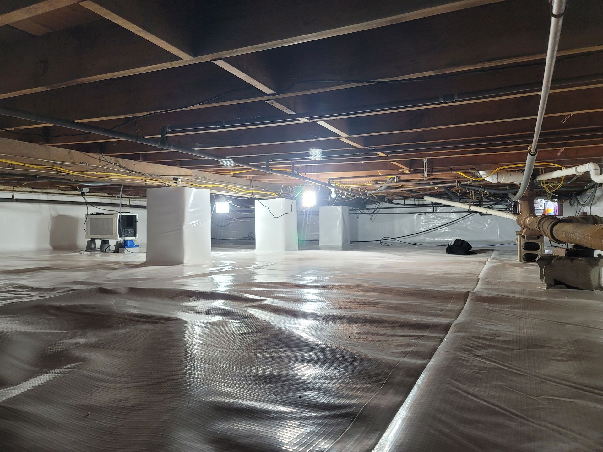 A very large empty basement with a lot of pipes.