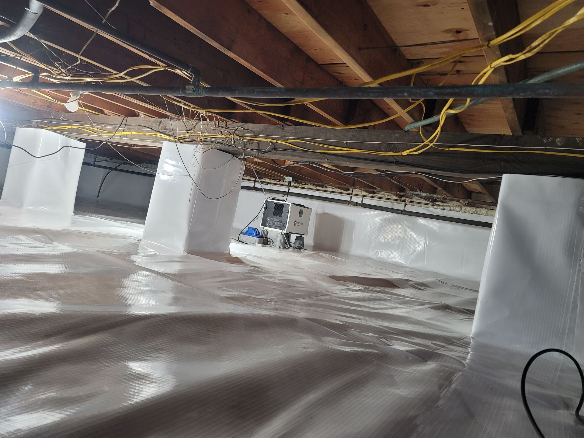A basement with a lot of wires hanging from the ceiling.
