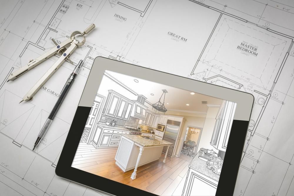 Tablet displaying a kitchen design sketch atop architectural blueprints, with drafting tools nearby.