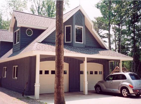 Two-car garage with a gray vehicle parked under a covered area.