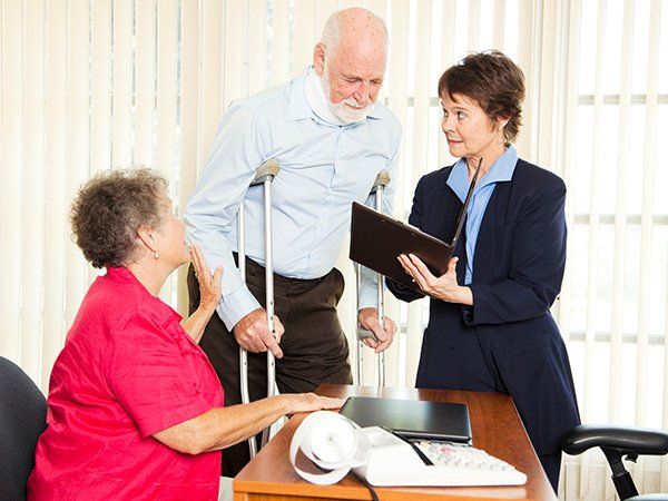Injured Man with Crutches with Wife Meeting Lawyer — Joliet, IL — The Law Offices of Edward R. Jaquays