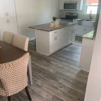 A kitchen with a table and chairs and a large island.
