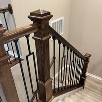 A wooden staircase with a metal railing in a house.
