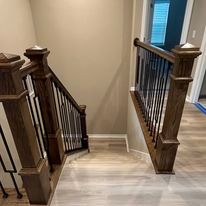 A wooden staircase with a metal railing in a house.
