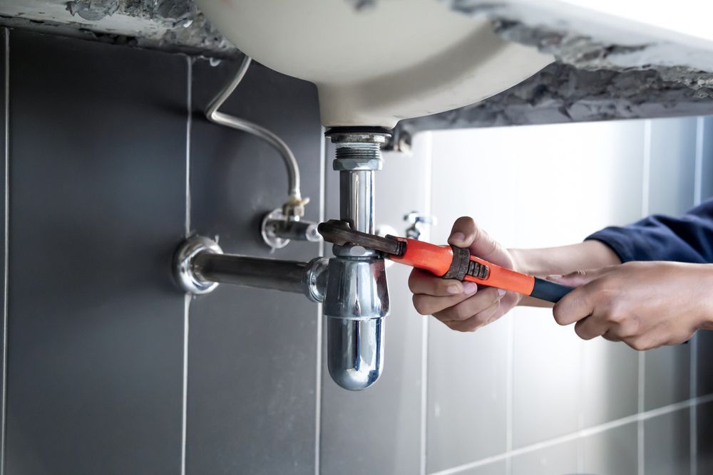 Plumber is Fixing a Sink Pipe With a Wrench — ASAP Local Plumbing in Warrnambool, VIC