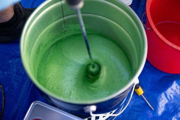Close-up of garage floor with pink, black, and white chips, a slight raised edge at the door.