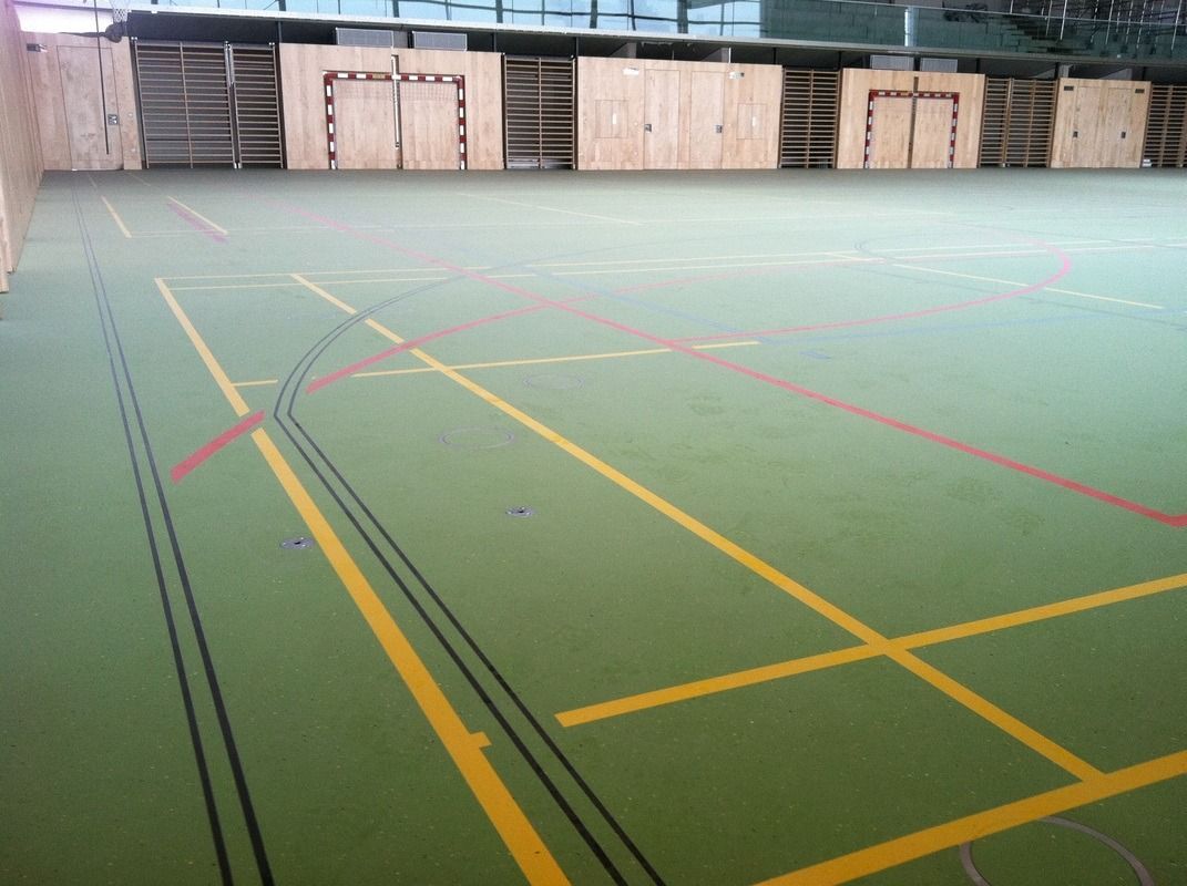 A basketball court with yellow lines and red lines, on a Hart's Athletic installed floor.
