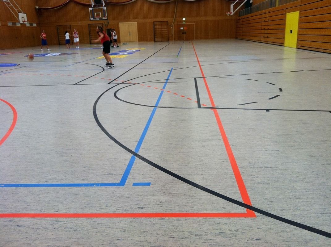 A basketball court with red and blue lines on it, on a Hart's Athletic installed floor.
