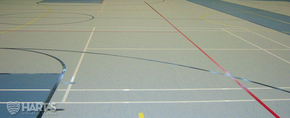 A basketball court with a red line on the floor, on a Hart's Athletic installed floor.