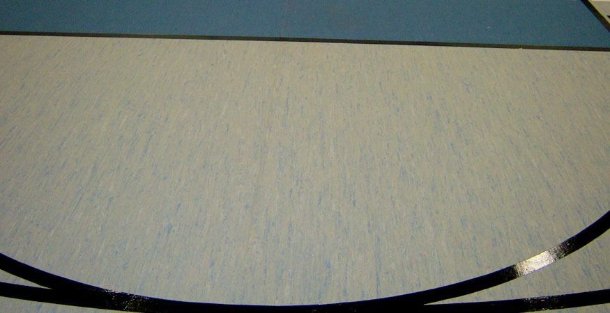 A white floor with a blue mat on it, on a Hart's Athletic installed floor.