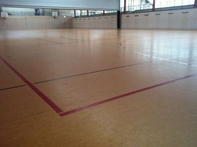 An empty gym with a red line on the floor, on a Hart's Athletic installed floor.