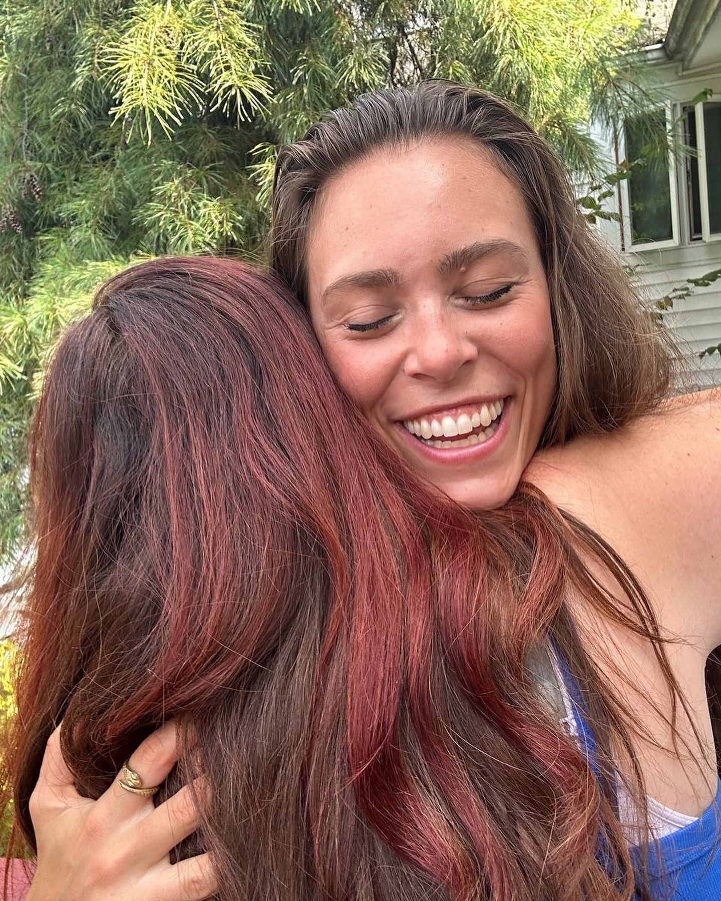 Two women are hugging each other and smiling.
