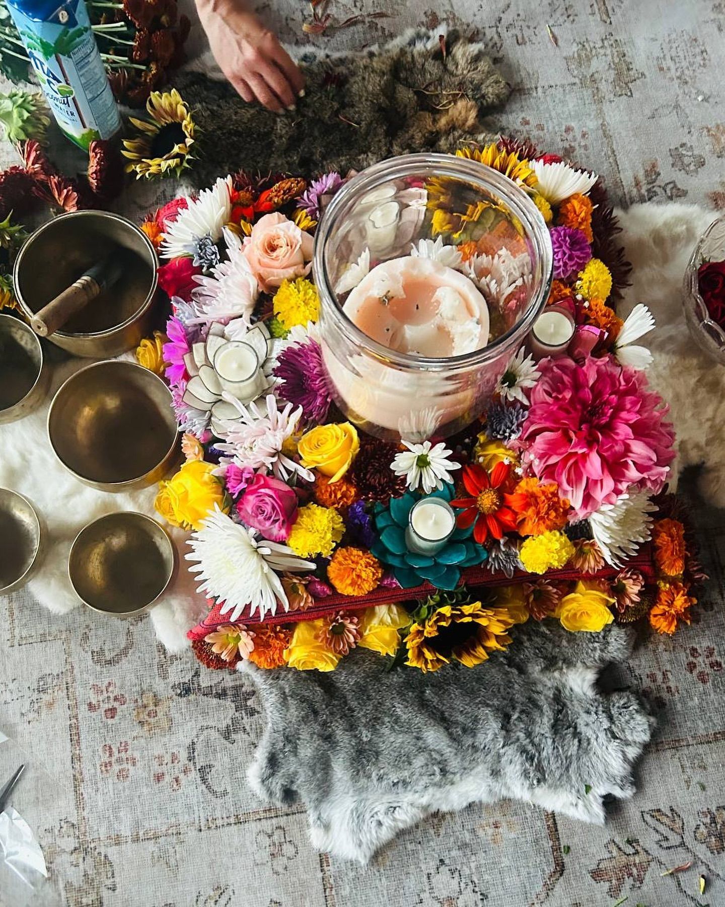 A table topped with flowers and candles and bowls.