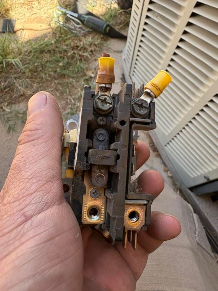 Hand holding a damaged electrical contactor