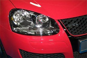 close up of a Car Headlight on a red car