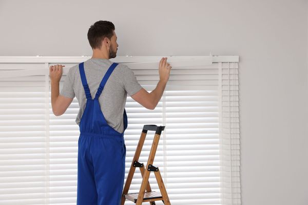 Man Installing Window Blinds