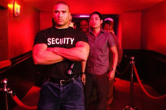 A security guard with his arms crossed in a hallway