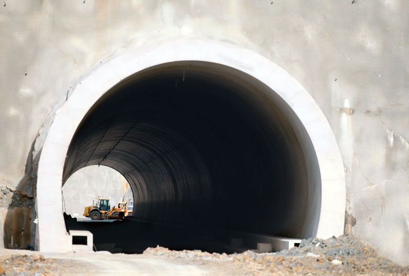 A bulldozer is driving through a tunnel under construction.