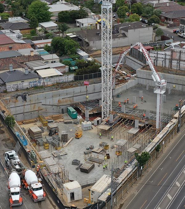An aerial view of a construction site with trucks and a crane.