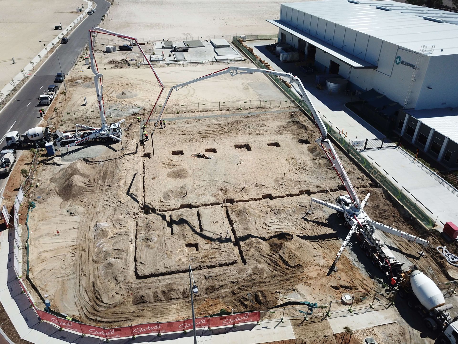 An aerial view of a construction site with a large building in the background.