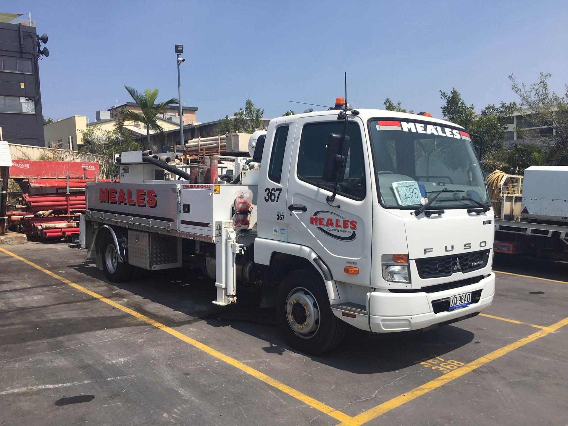 A white tow truck is parked in a parking lot.