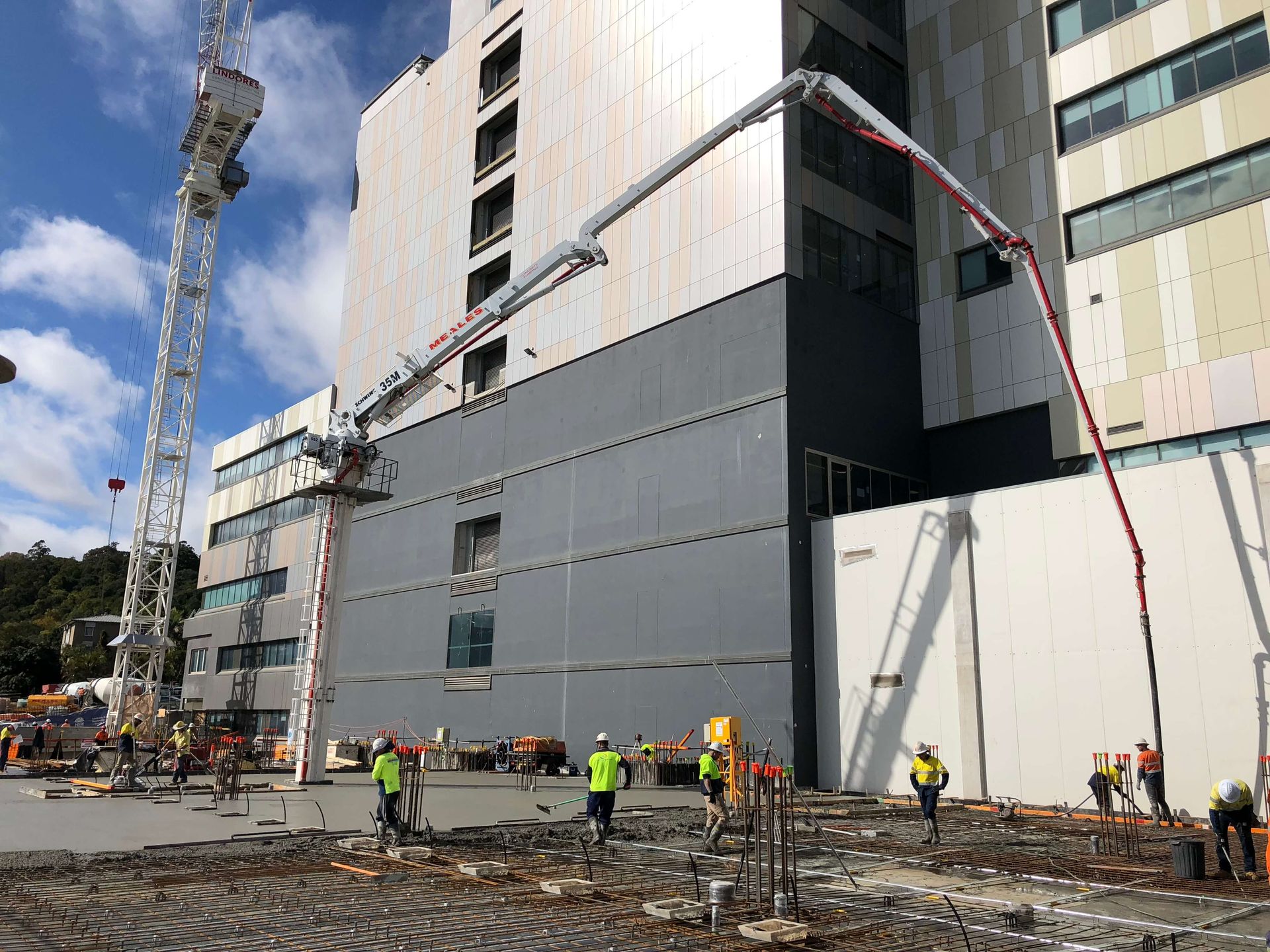 A group of construction workers are standing in front of a large building.