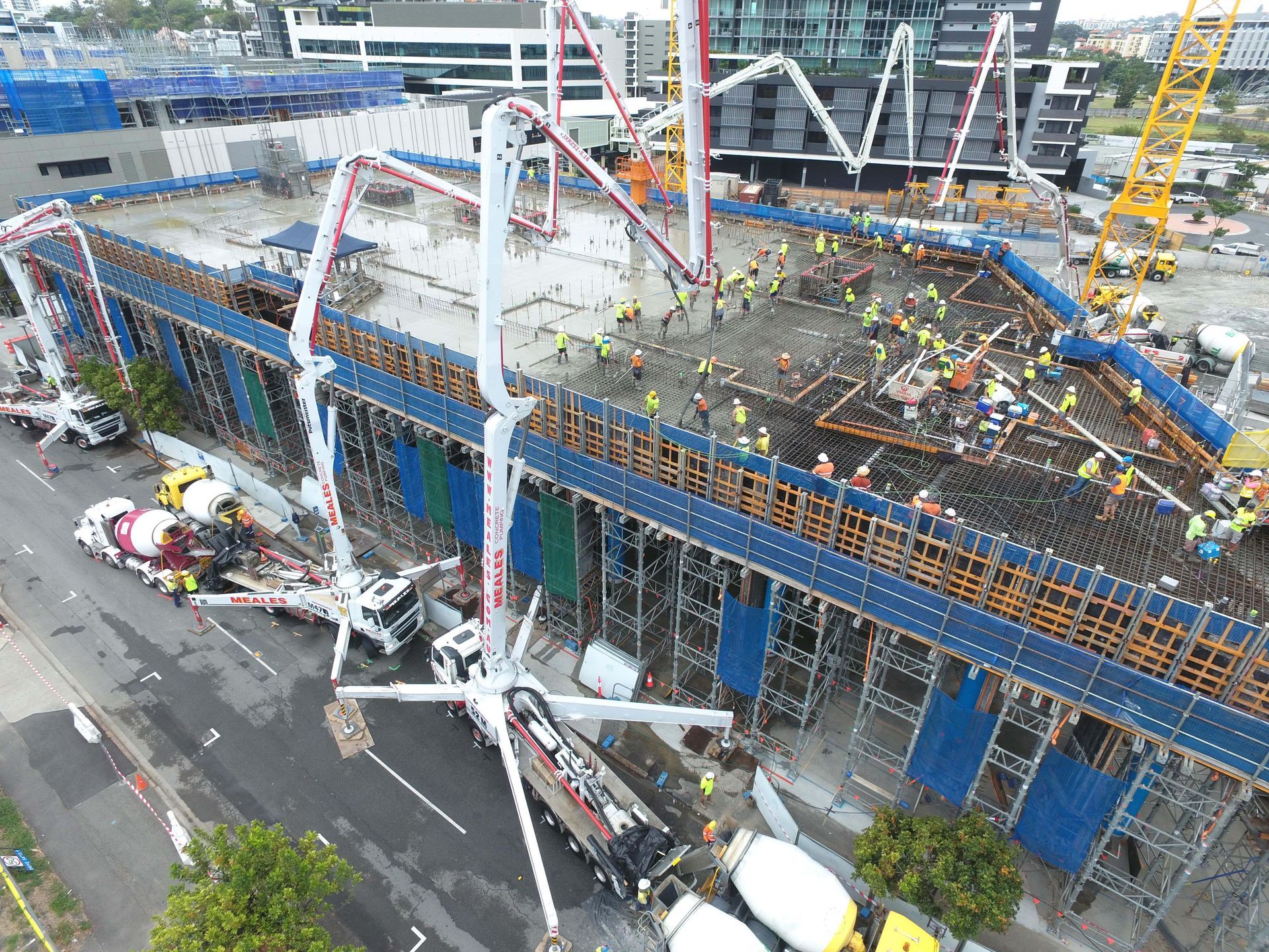An aerial view of a building under construction with a concrete pump.
