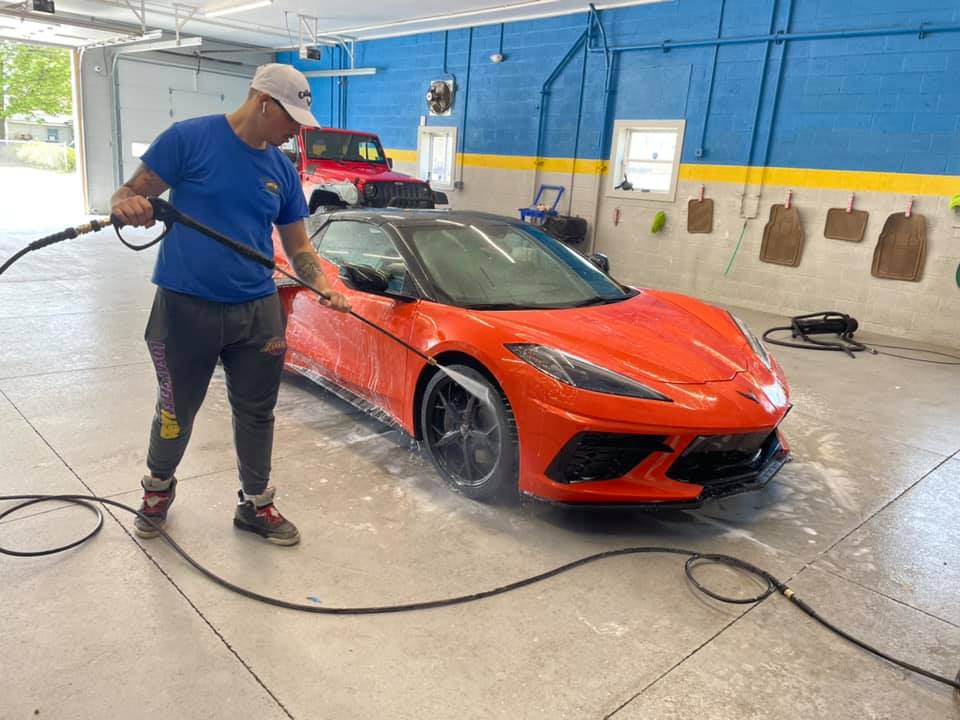 Man Cleaning the Orange Car — Erie, PA — Sparkle Clean Car Care