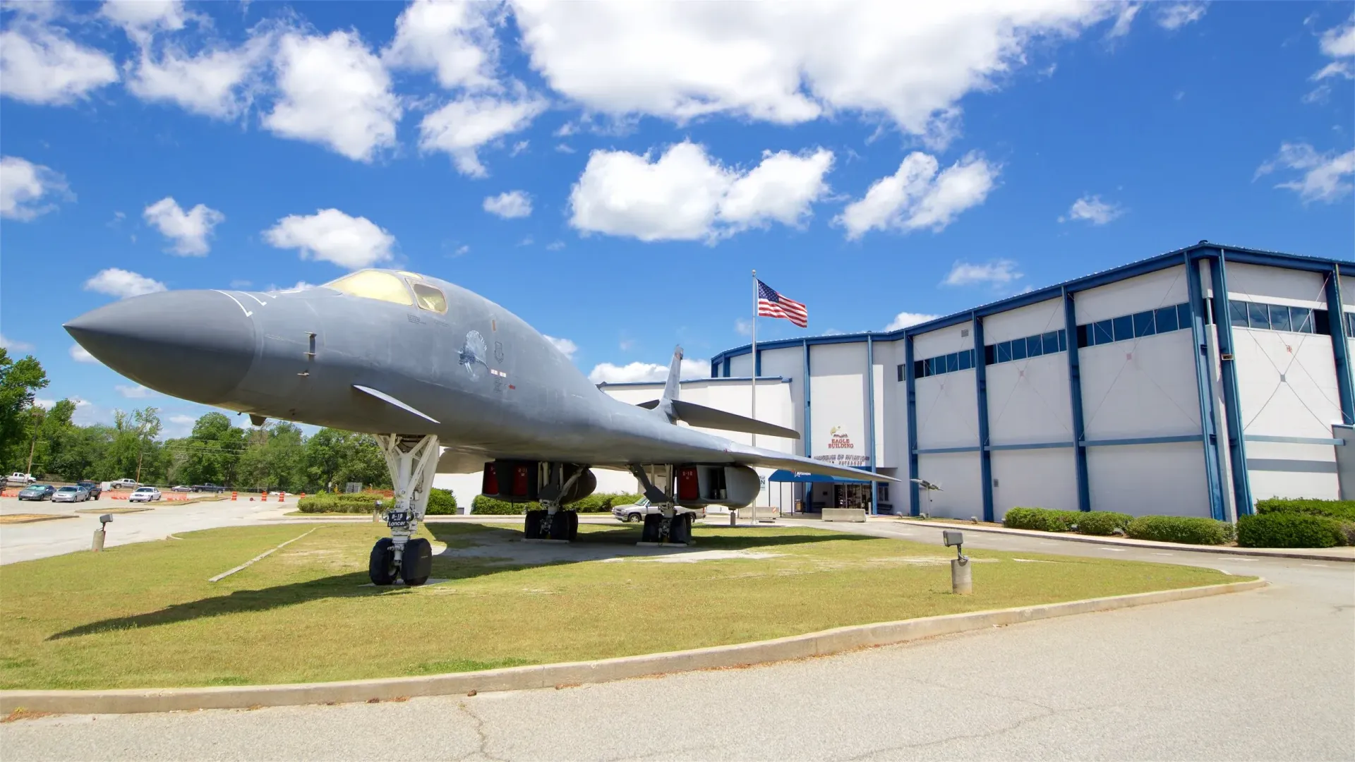 A large fighter jet is parked in front of a building.