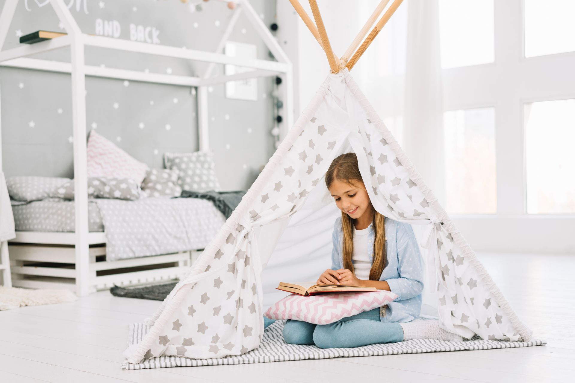 Young girl reading in bedroom