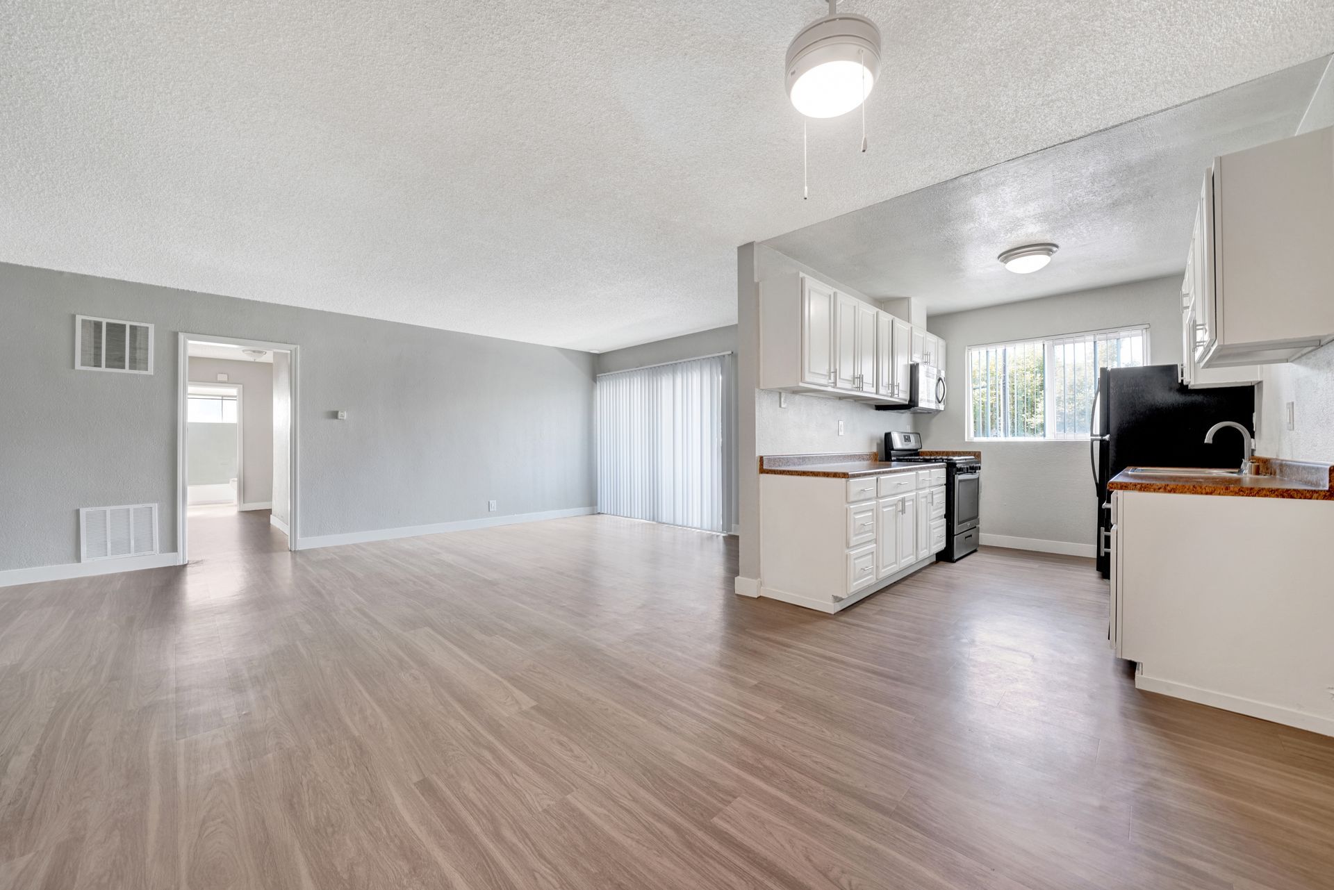 Photo of a very large, open living room/dining room area, with a kitchen to the side