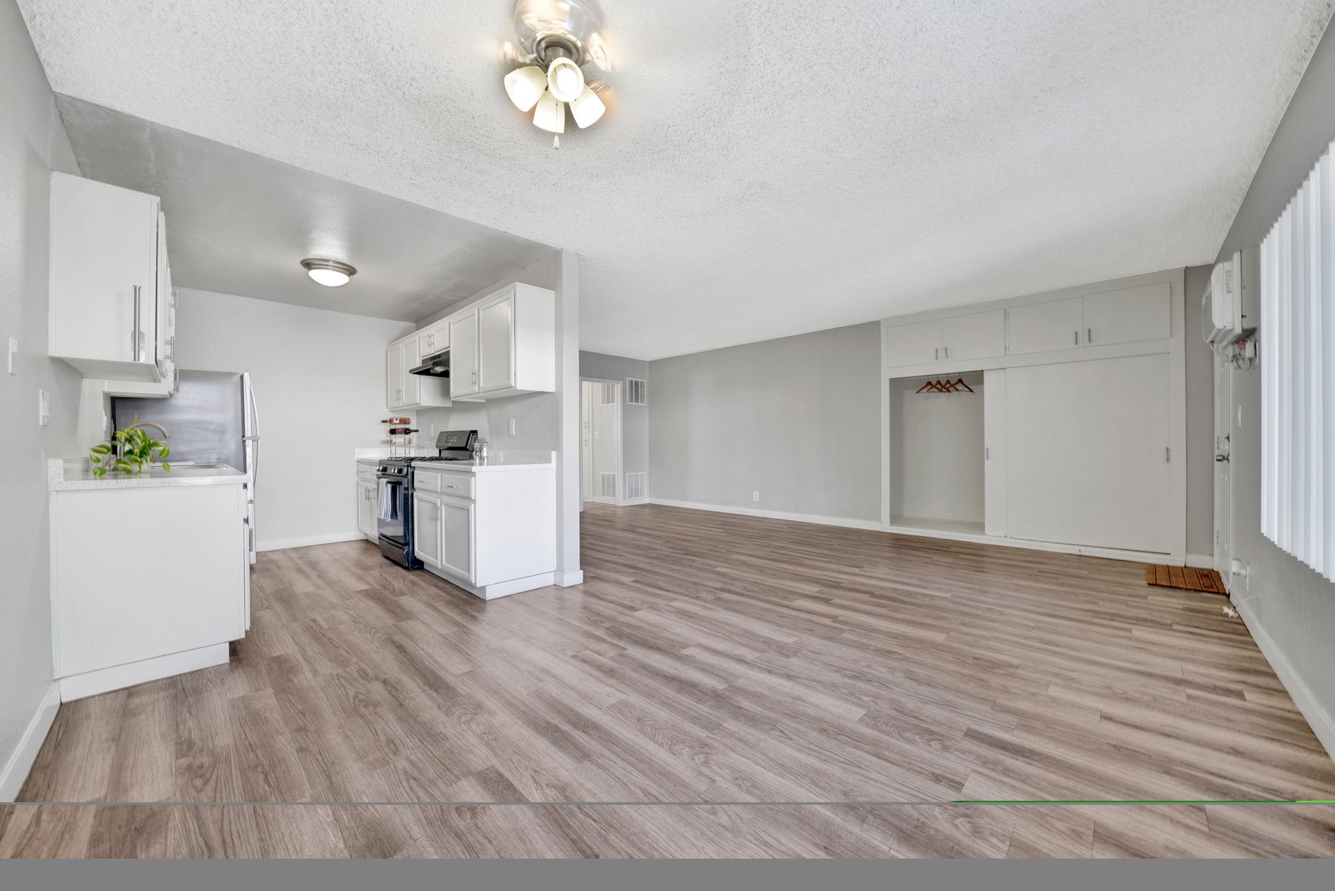 Photo of the dining area, showing the kitchen in the foreground and the living room area in the background