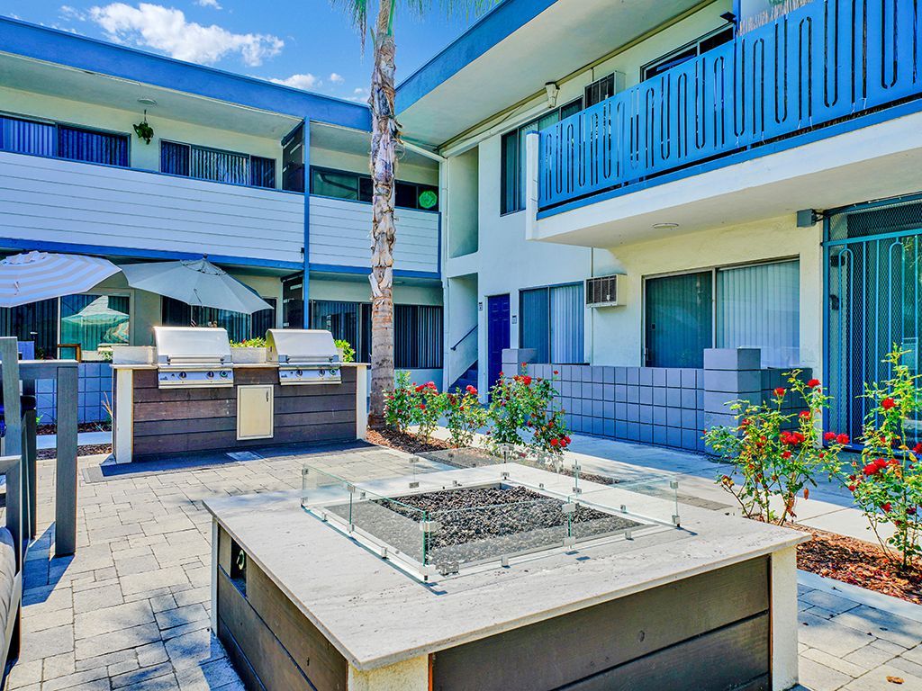 Photo of a firepit, with a set of barbecue grills in the background
