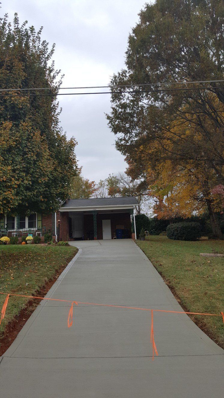 A concrete driveway leading to a house with a garage.