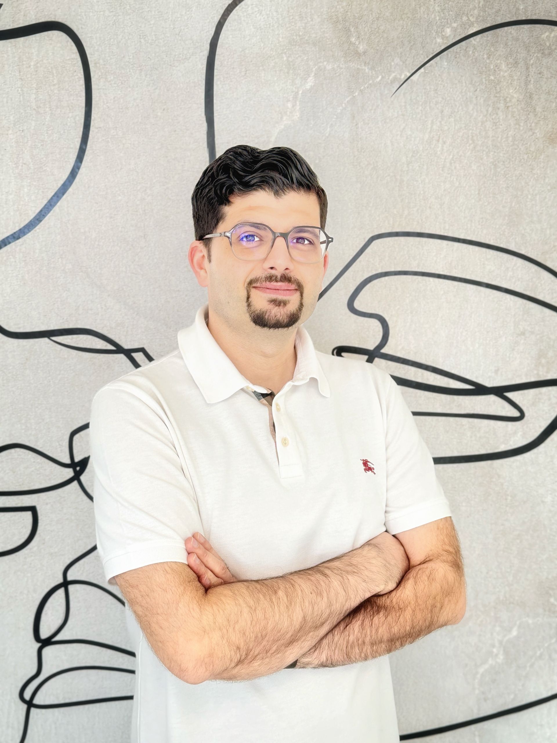 Ein Mann in einem weißen Poloshirt mit verschränkten Armen