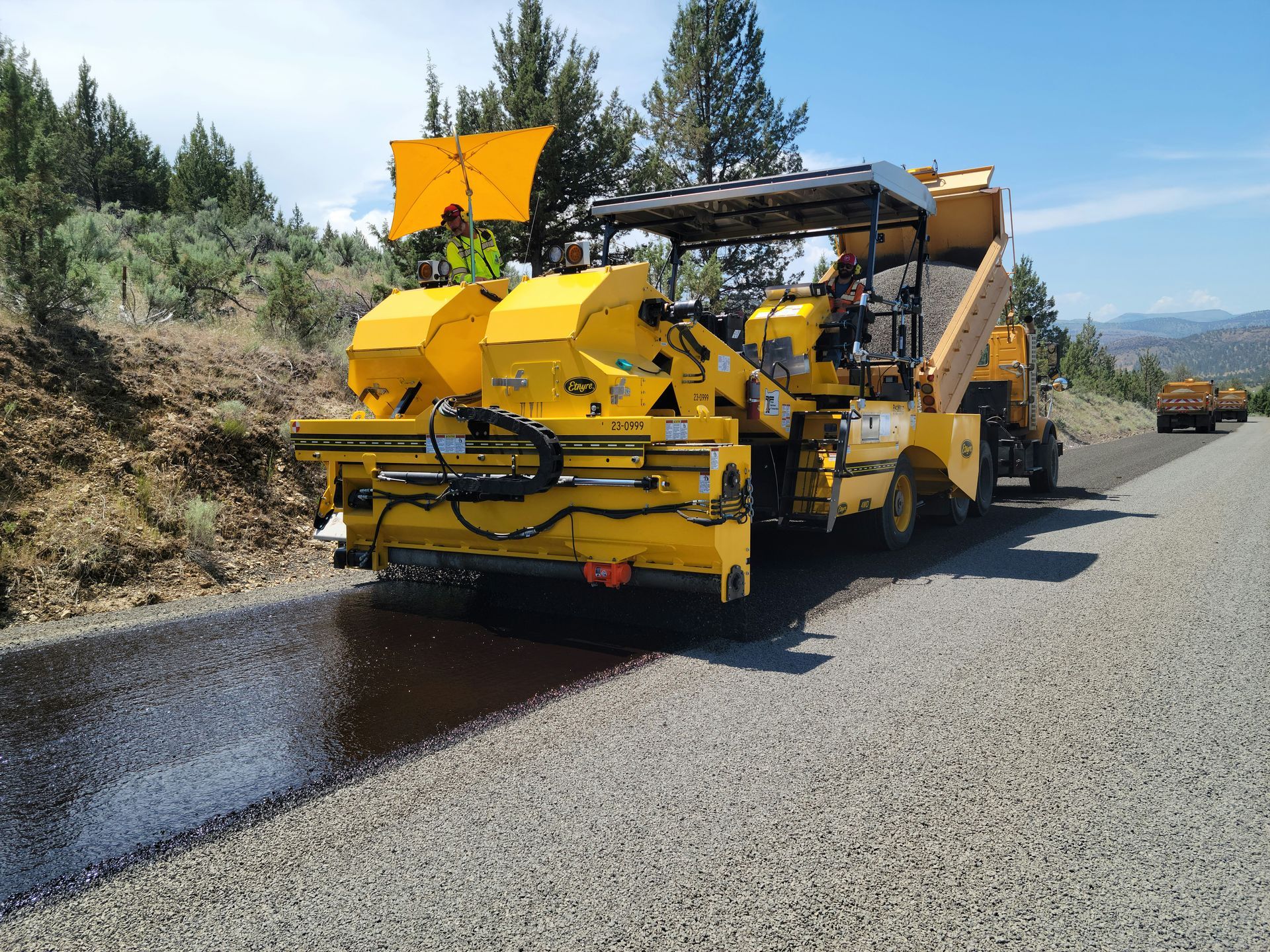 Crew sealcoating new asphalt on a road
