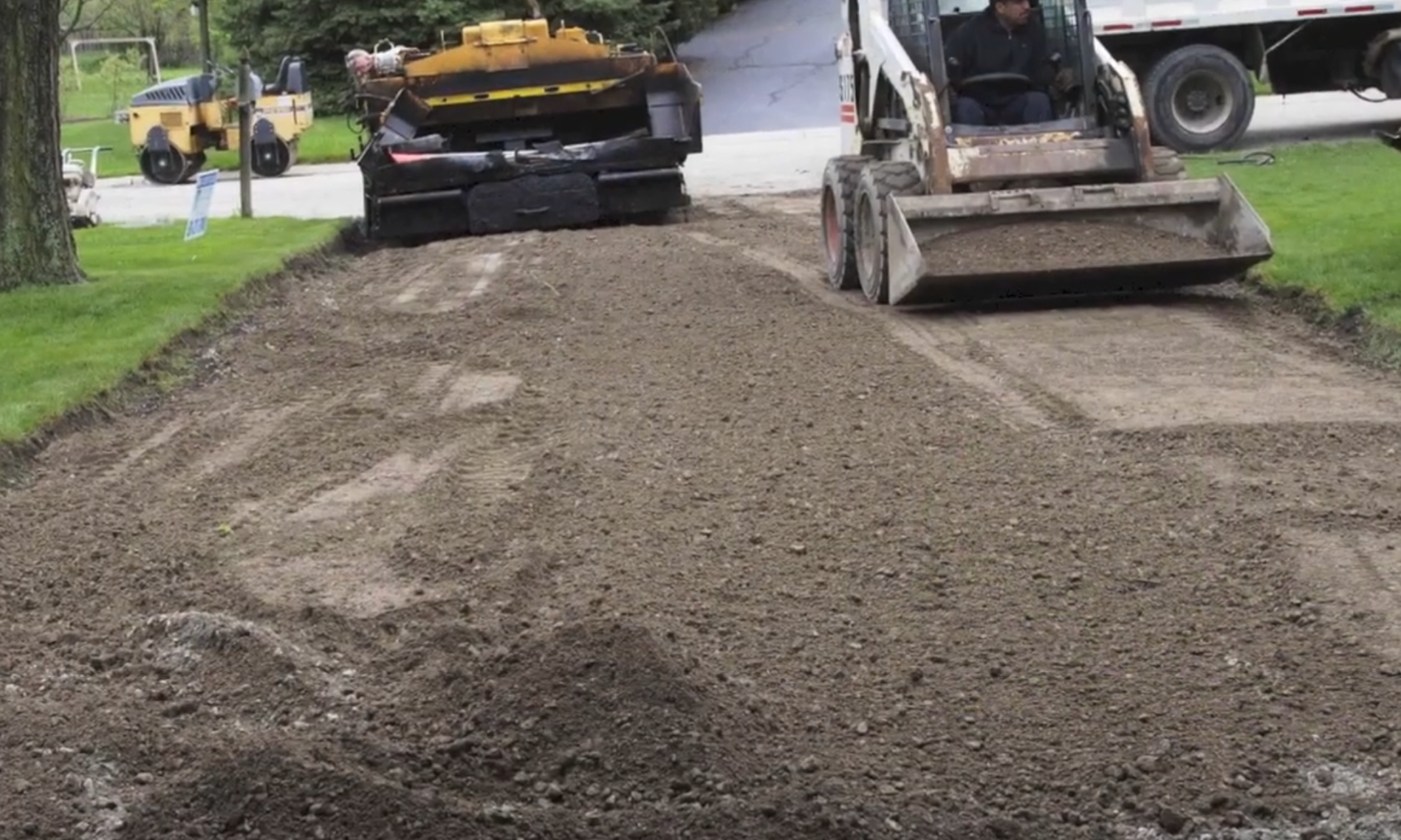 Asphalt crew prepping ground for driveway