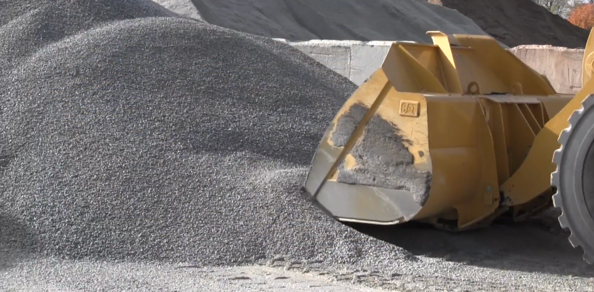 Crew member loading recycled material from milling to remix