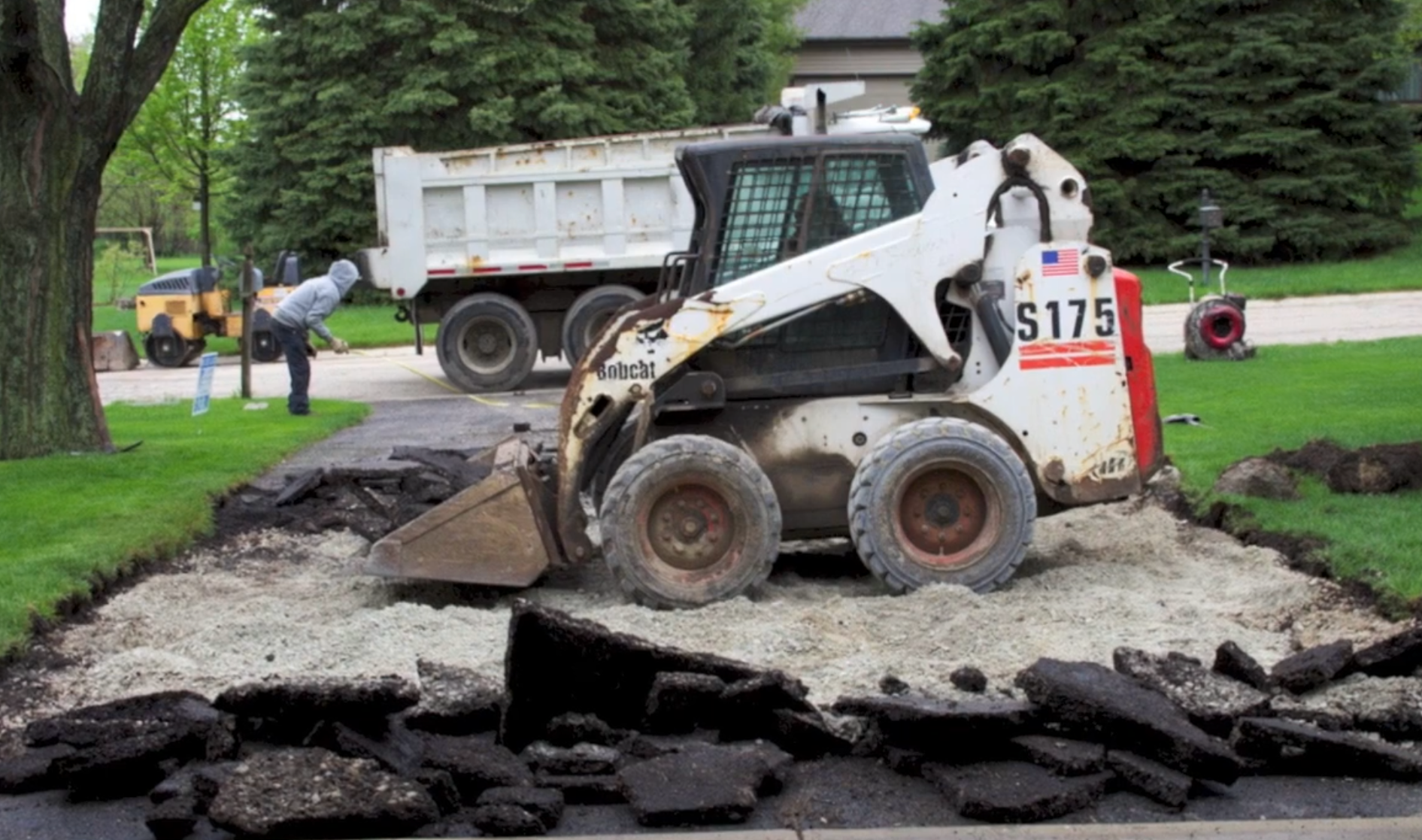 Crew removing old asphalt from driveway