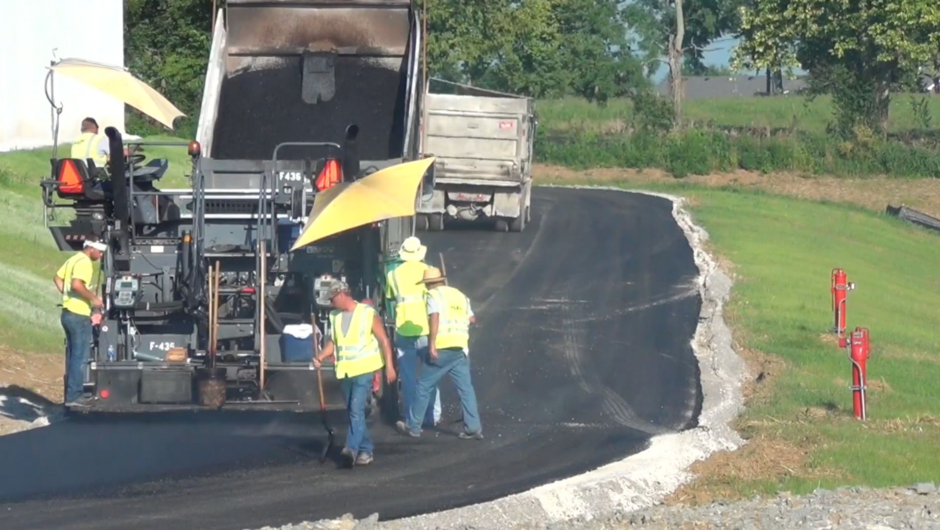Crew members smoothing asphalt 