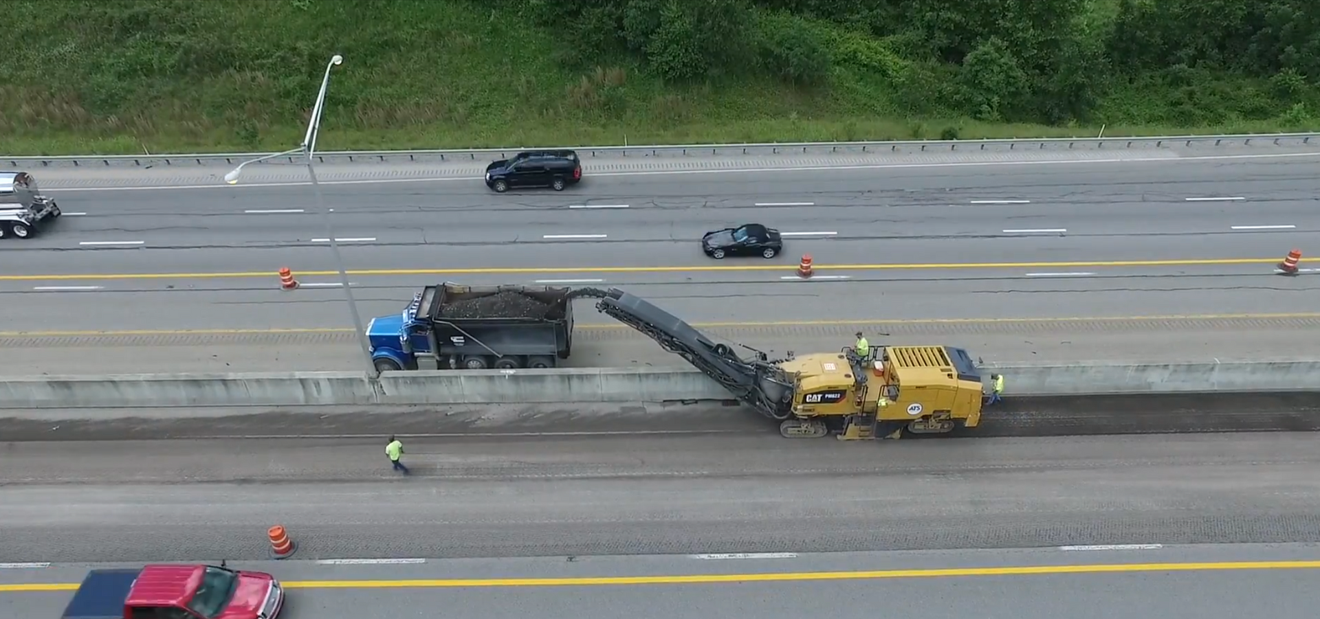 Crew milling asphalt on highway