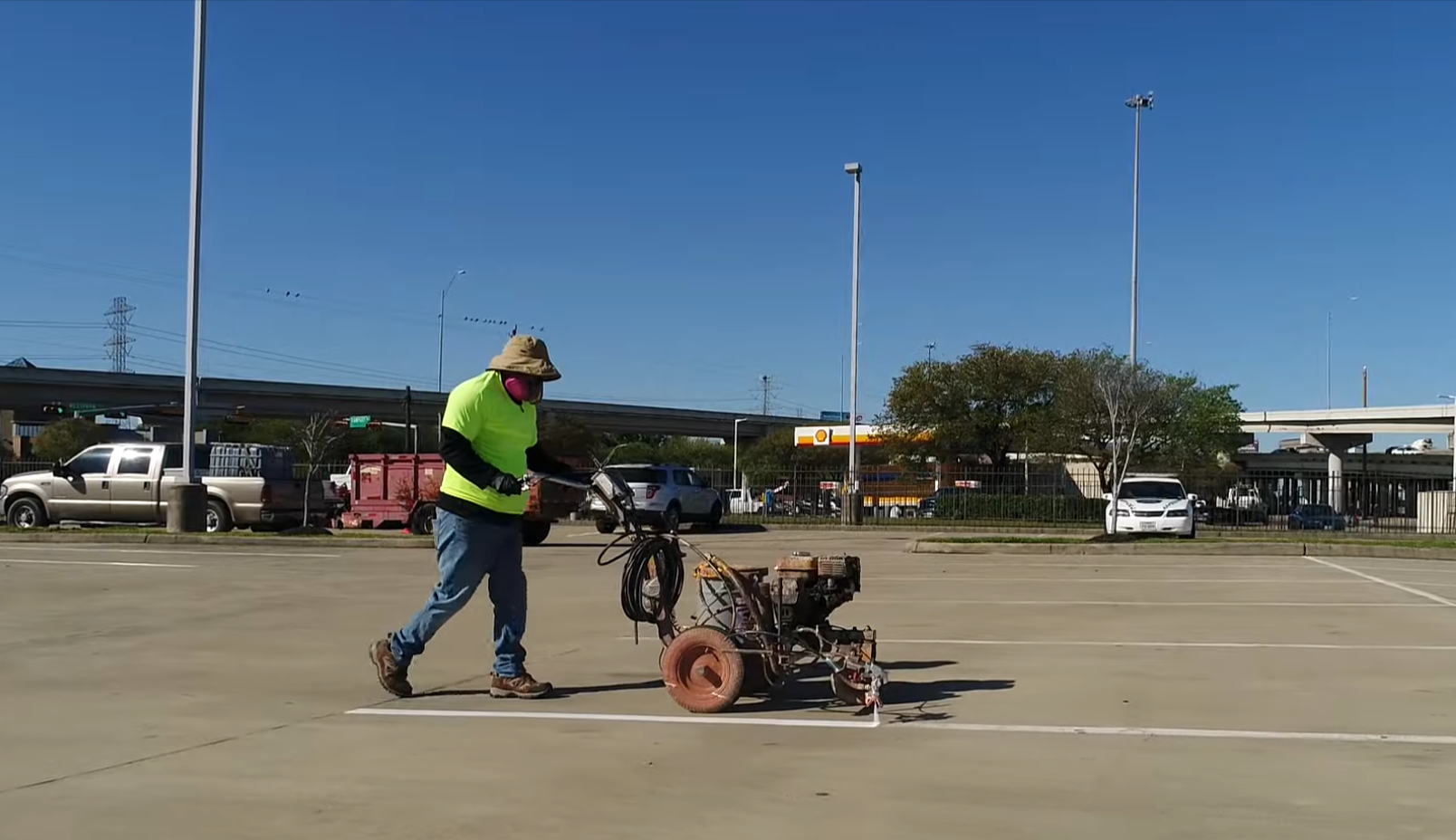 Crew member striping an asphalt parking lot