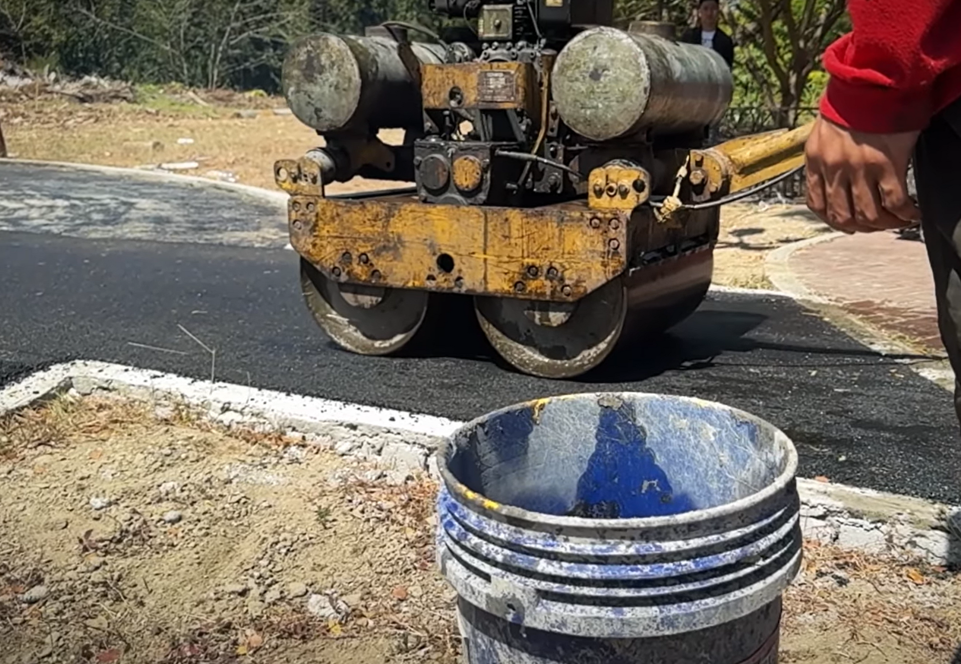Man repaving walkway with asphalt