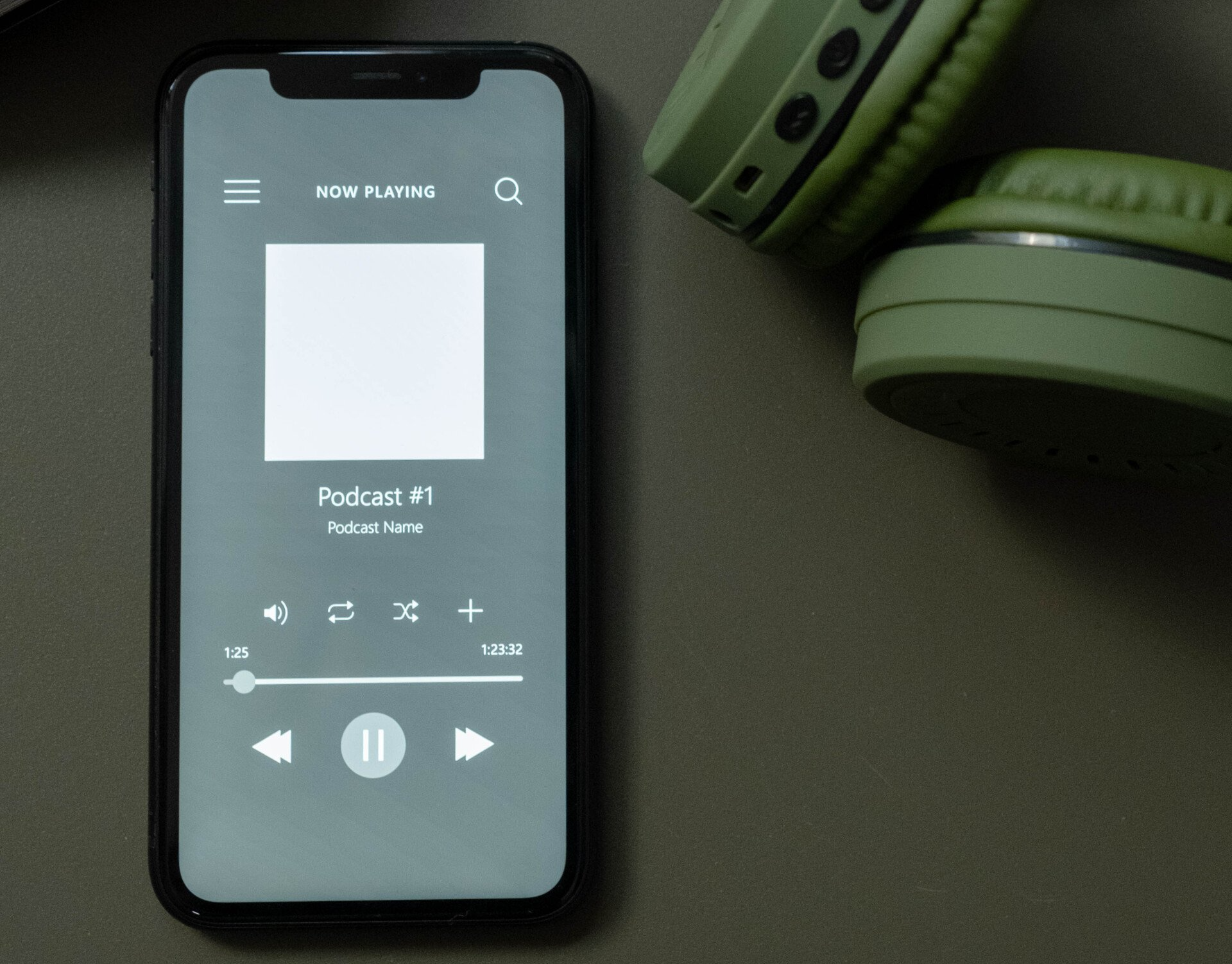 A phone with a podcast on the screen next to headphones.